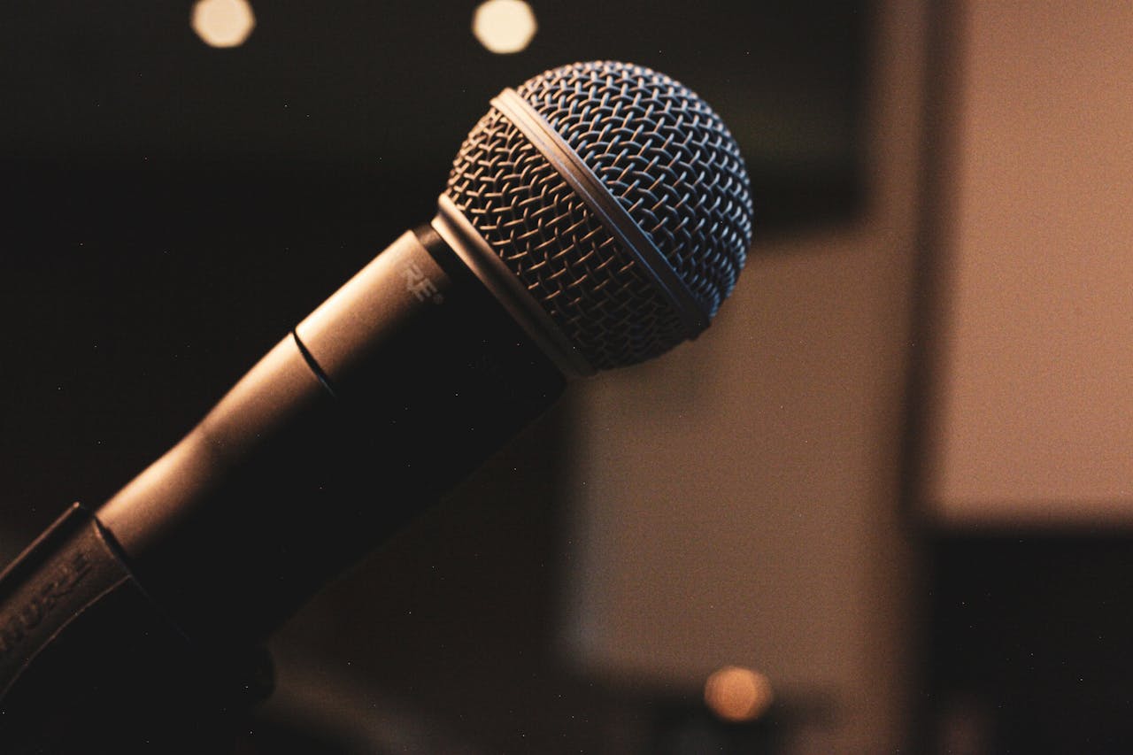 Extreme close-up of a microphone in focus with a blurred background, ideal for music or podcast themes.